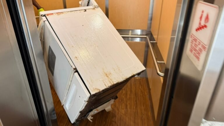 Old stove being moved onto an elevator for removal