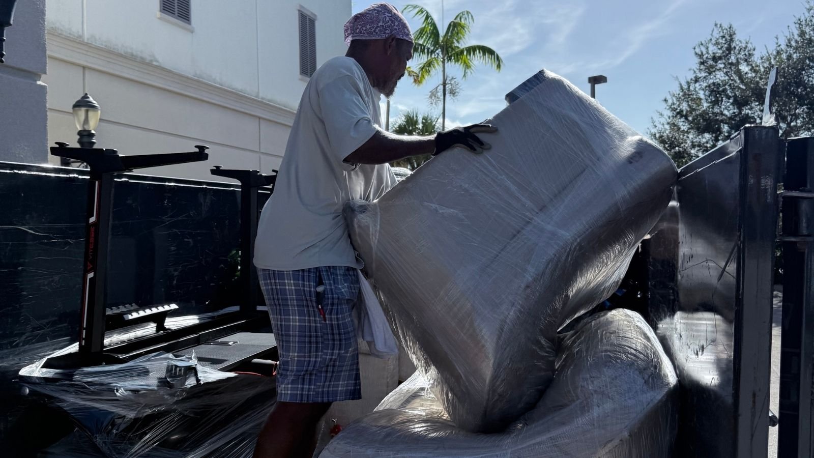 Sofa being loaded into High Caliber Junk Removal trailer